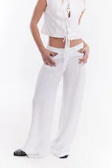 Pantalón sastrero de lino italiano color beige, de corte recto y holgado, con aberturas laterales en la cintura y pinzas.