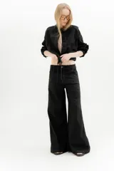 Pantalón ancho color ocre, de tiro medio, confeccionado en lino y algodón. Presenta bolsillos delanteros y traseros con triple pespunte en contratono y remaches.