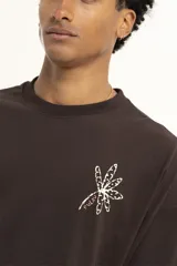 Remera marrón de corte holgado con estampado de una flor en el pecho.