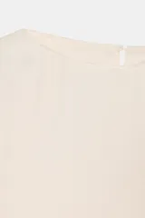 Top fluido de manga corta de Zara Woman Collection, confeccionado en hilatura de viscosa de color crudo. Cuenta con cuello barco, bajo recto y cierre en la espalda con pequeña abertura y botón.