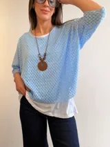 Buzo azul marino con diseño calado de manga corta y corte oversize, acompañado por una musculosa blanca básica interior.