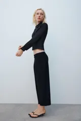 Camisa de denim negra con cuello solapa, manga larga, pespuntes a contraste y cierre frontal con cremallera metálica.