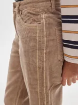 Pantalón de pana roja con corte holgado y tiro medio. Presenta una línea dorada a lo largo de la pierna.