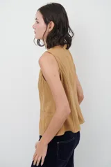 Chaleco de gamuza color caramelo, con cierre frontal de botones y bolsillos laterales simulados.