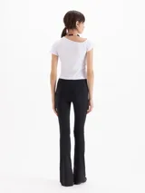 Pantalón Margot de microfibra negra, de tiro alto y silueta ajustada con botamangas acampanadas y tajos laterales.