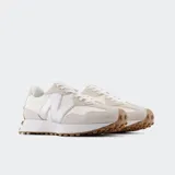 Championes New Balance 327 de diseño retro con capellada en tonos beige y off-white, con el logo 'N' lateral metalizado en color plateado, suela blanca y suela exterior de goma marrón con tacos extendidos.