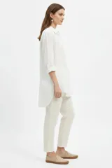 Camisa blanca de viscosa de corte oversize, con cuello camisero, cierre frontal de botones y bolsillo ojal en el pecho.