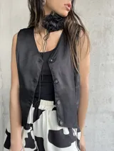 Chaleco sastrero negro con botones, de corte corto y moderno.