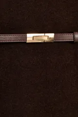 Jersey de punto liso confeccionado en 100% lana, con cuello subido y manga larga. Incluye un cinturón fino integrado en la cintura con hebilla metálica.