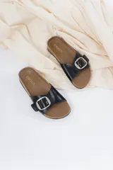 Sandalias negras de cuero sintético con hebilla metálica ajustable y plantilla anatómica.