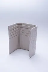 Billetera negra de cuero con textura tipo cocodrilo, con múltiples ranuras para tarjetas y billetes.