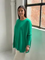 Sweater de punto color verde, con cuello redondo, mangas largas con puños acanalados y diseño holgado con detalle de costura vertical central.