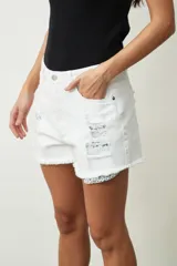 Short de jean blanco con roturas y terminación desflecada.