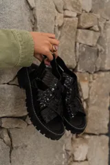 Sandalias de cuero color mostaza con tiras anchas cruzadas y suela track negra.