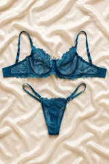 Conjunto de lencería de encaje color turquesa, compuesto por un soutiene con aro y tirantes regulables, y una tanga regulable con tiras finas.