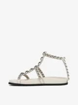 Sandalias planas color blanco con tiras decoradas con tachas plateadas y cierre de velcro.