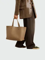 Bolso tote de cuero color beige claro, con asas superiores y silueta rectangular.