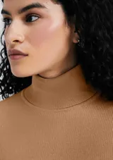 Polera de manga larga con cuello alto y diseño ajustado, confeccionada en tejido de punto liso color naranja.