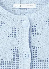 Chaleco celeste de punto con diseño de flores perforadas, sin mangas, escote redondo y cierre frontal con botones.