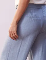 Pantalón largo celeste de lino, marca Zac & Rachel, corte wide leg, pretina con botones, cierre y broche metálico, bolsillos verticales delanteros y bolsillos simulados traseros.