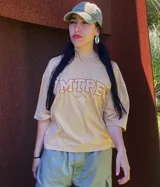 Remera color arena con cuello redondo y estampado frontal con letras "MTPE" en marrón.