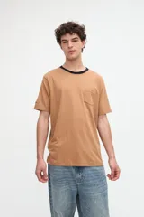 Remera blanca de algodón con textura suave, corte relaxed, manga corta, cuello redondo en contraste de color celeste y un bolsillo aplicado en el pecho.