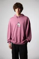 Buzo hoodie color lila con cordones ajustables, bolsillo tipo canguro y puños y cintura acanalados. Estampado frontal con un personaje de caricatura surfeando y el texto "blue bananas".