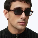 Lentes de sol modelo Kya de silueta rectangular oversized, con montura gruesa de carey y lentes polarizadas oscuras.