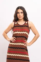Vestido largo de tejido de punto con patrón en zigzag de rayas en tonos marrón, rojo, negro y beige, sin mangas y con escote redondo.