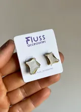 Par de aros pequeños con forma de estrella de cuatro puntas, hechos a mano en bronce o alpaca y nácar.