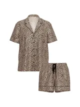 Pijama corto de satín con estampado animal print de leopardo. Incluye una camisa de manga corta con botones frontales, cuello solapa y ribetes negros, junto con un short con cintura elastizada y cordón ajustable.