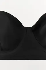 Sujetador de color blanco hueso o crema, con aros y copas moldeadas, corte recto en el bajo y tirantes finos ajustables y extraíbles.