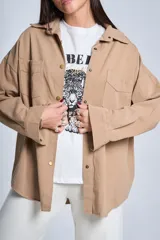 Sobrecamisa color beige de gabardina con cuello camisero, cierre frontal con botones a presión, dos bolsillos de parche en el pecho y corte holgado.