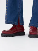Zapato tipo guillermina de cuero color bordó, con diseño de mocasín, hebilla metálica y suela de goma con plataforma dentada.