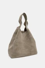 Bolso mini shopper de piel color gris topo, con doble asa de mano y asa bandolera extraíble. Cuenta con bolsillo interior con cremallera y cierre mediante botón imantado.