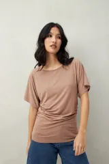 Remera negra de manga corta, confeccionada en modal, con cuello bote y frunces laterales.