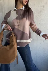Sweater de punto con diseño de bloques de color en tonos tierra y beige, de corte oversize, cuello redondo y manga larga.
