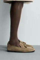 Mocasín de vestir para hombre, confeccionado en piel con acabado serraje de color tostado, con detalle de borlas en el empeine y suela de ligero tacón.