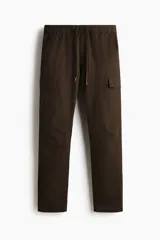 Pantalón cargo slim fit marrón, con cintura elástica ajustable mediante cordón, bolsillos laterales con solapa y costuras decorativas en las rodillas.