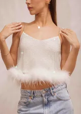 Top musculosa color blanco con brillos y tirantes de cadena. Presenta plumas en el ruedo.