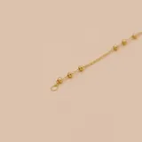 Pulsera de cadena fina en oro 18k con pequeñas esferas distribuidas a lo largo de toda la pieza y cierre de resorte.