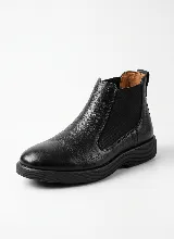 Bota tipo Chelsea de cuero negro con paneles laterales elásticos y suela de goma texturizada.