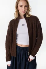 Campera de punto tejido color beige con diseño de ochos, cuello alto y cierre frontal completo.