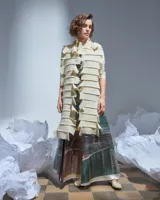 Bufandón de lana merino afieltrada color natural, formado por piezas horizontales unidas que generan una textura continua.