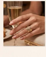 Anillo ancho de bronce con baño de oro, diseño texturizado en relieve y detalles de circonias engarzadas.