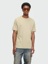 Remera de algodón color beige, manga corta y cuello redondo. Presenta un pequeño logo bordado en el pecho.