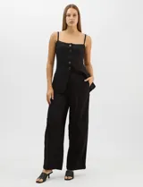 Conjunto monocromático compuesto por un top de breteles finos con escote recto y cierre frontal de botones, y un pantalón de tiro alto con pierna amplia y bolsillos laterales.