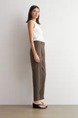 Pantalón de vestir marrón de corte barrel, con pinzas frontales marcadas y botamanga recta.