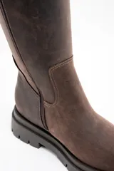 Bota de caña media confeccionada en cuero legítimo con efecto lavado. Presenta una suela track robusta de goma con relieve y costuras reforzadas en el cuerpo de la bota.
