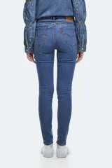 Jean ajustado (skinny) de tiro alto, color azul medio, con efecto levemente desgastado en la parte frontal de los muslos.